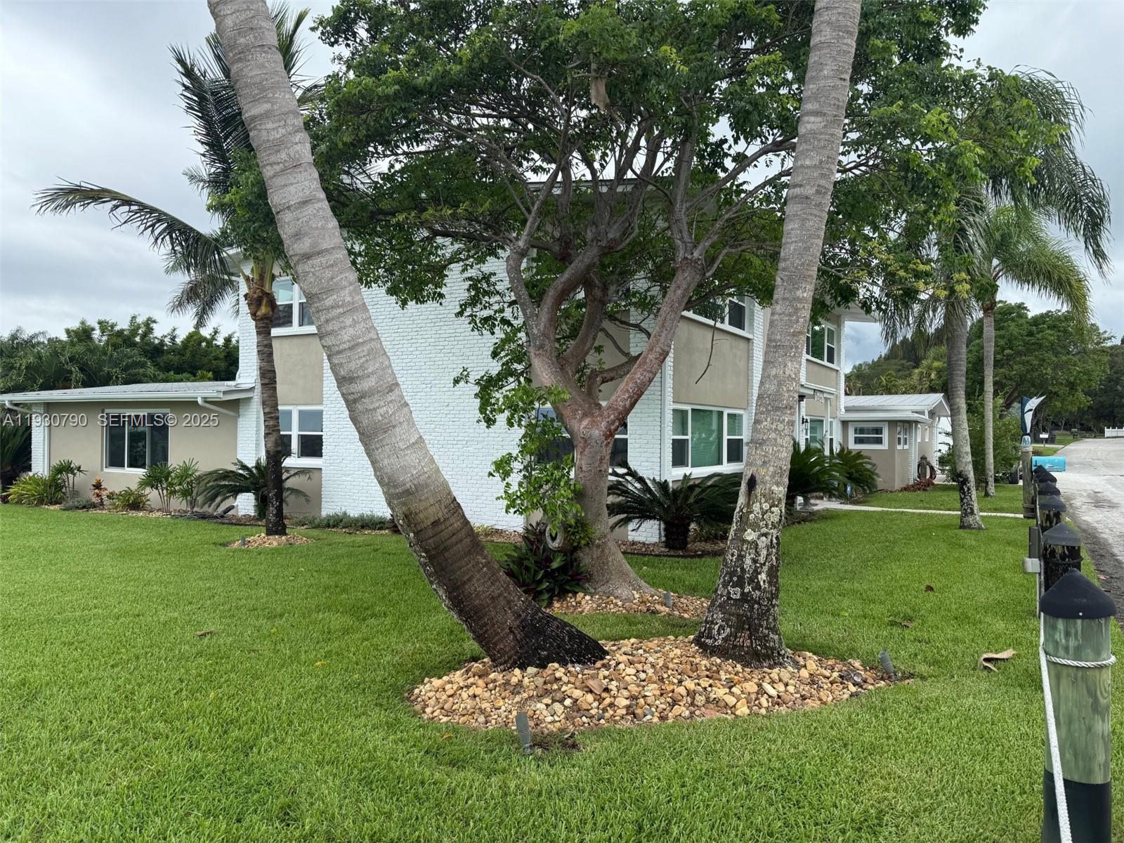 A two-story white brick house features palm trees and landscaping in the front yard — 13549 S Indian River Dr, Jensen Beach FL 34957, JENSEN BEACH, FL