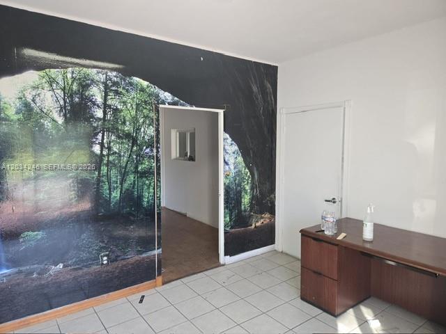 An office room features a forest-themed wall mural, white walls, tile flooring, and a desk — HIALEAH GARDENS, FL