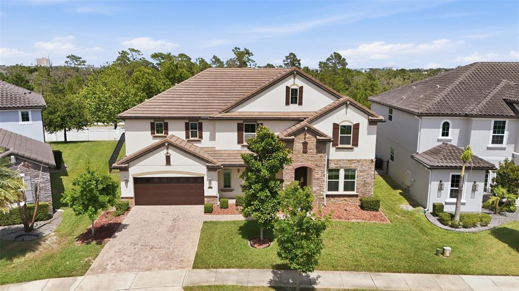 An aerial view shows a two-story suburban house with a stone facade and brown roof — 8210 LUDINGTON CIRCLE, ORLANDO, FL