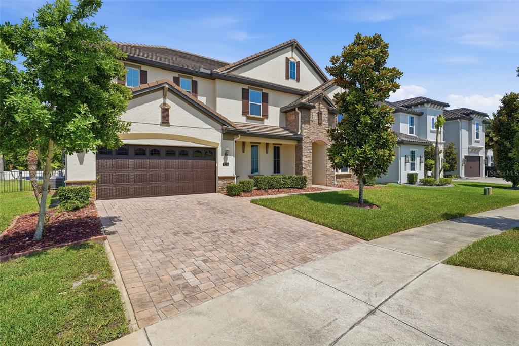 A two-story suburban house with a paved driveway, a two-car garage, and a landscaped lawn — 8210 LUDINGTON CIRCLE, ORLANDO, FL