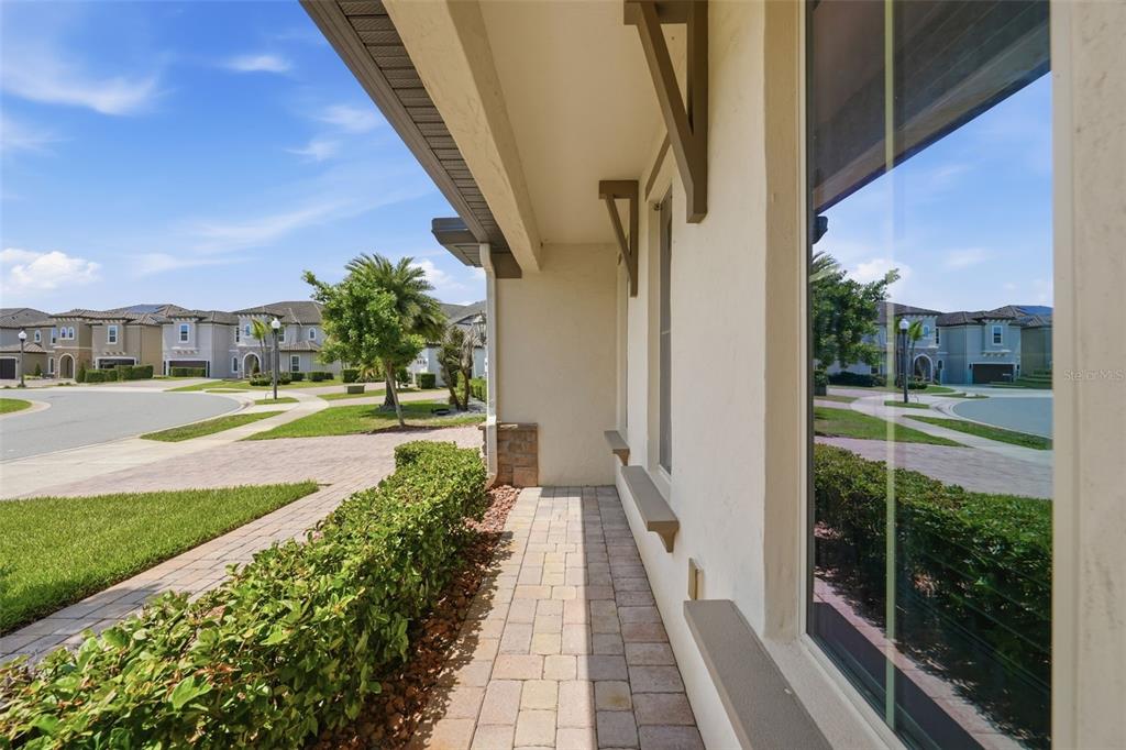 A paved walkway runs along the side of a house with a large window — 8210 LUDINGTON CIRCLE, ORLANDO, FL