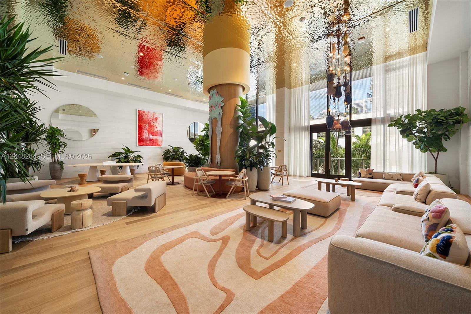 A spacious, modern lobby features a gold-textured ceiling, large central column, and contemporary lounge furniture — 90 NE 32 # 514, Miami FL 33127, MIAMI, FL