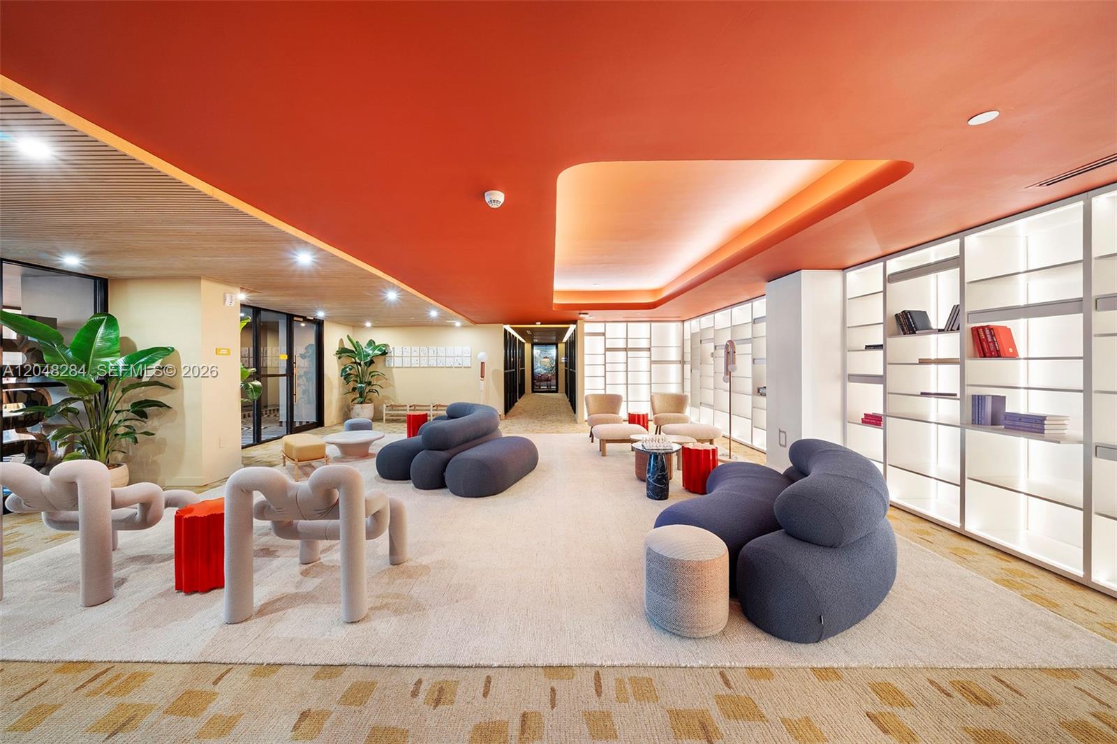 A modern lounge features curved blue sofas, sculptural chairs, and a recessed orange ceiling — 90 NE 32 # 514, Miami FL 33127, MIAMI, FL