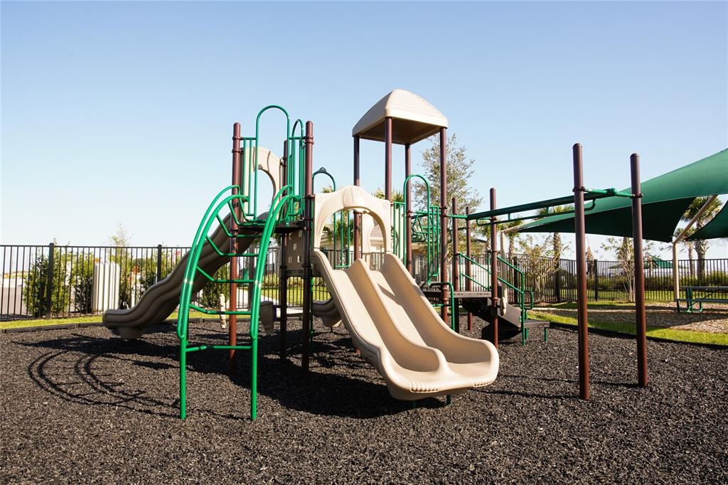 A playground with a multi-level structure, two slides, and a green shade canopy — 1030 TWINS STREET, DAVENPORT, FL