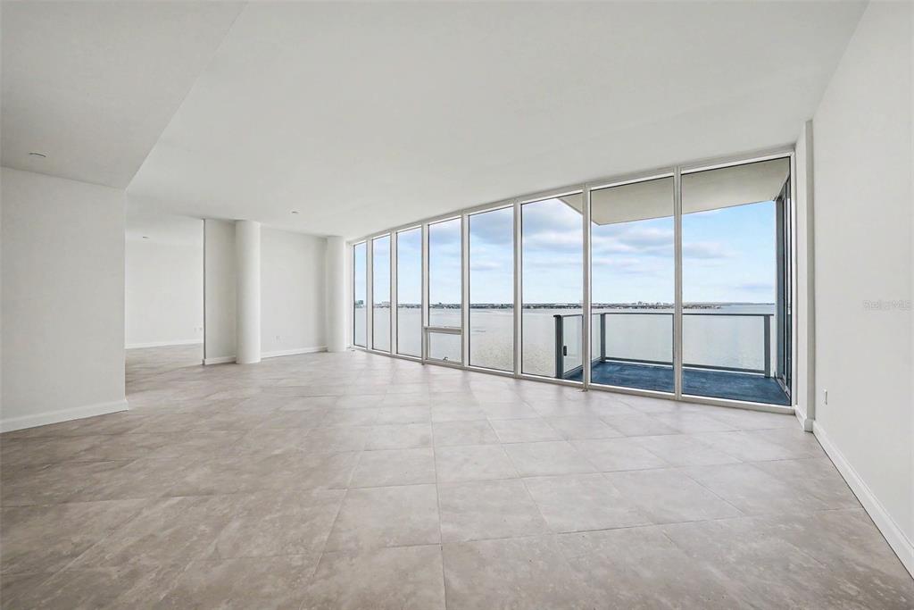 An empty room with large floor-to-ceiling windows, tile flooring, and a balcony overlooking water — 2900 W BAY TO BAY BOULEVARD UNIT 1502, TAMPA, FL