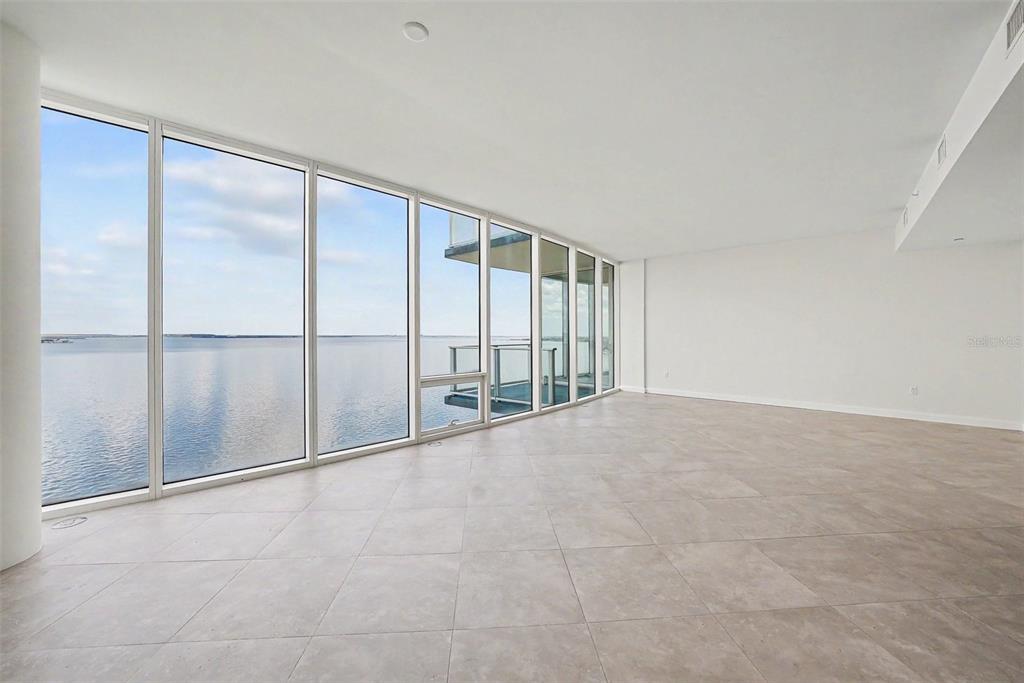 An empty room with large floor-to-ceiling windows overlooking a body of water — 2900 W BAY TO BAY BOULEVARD UNIT 1502, TAMPA, FL