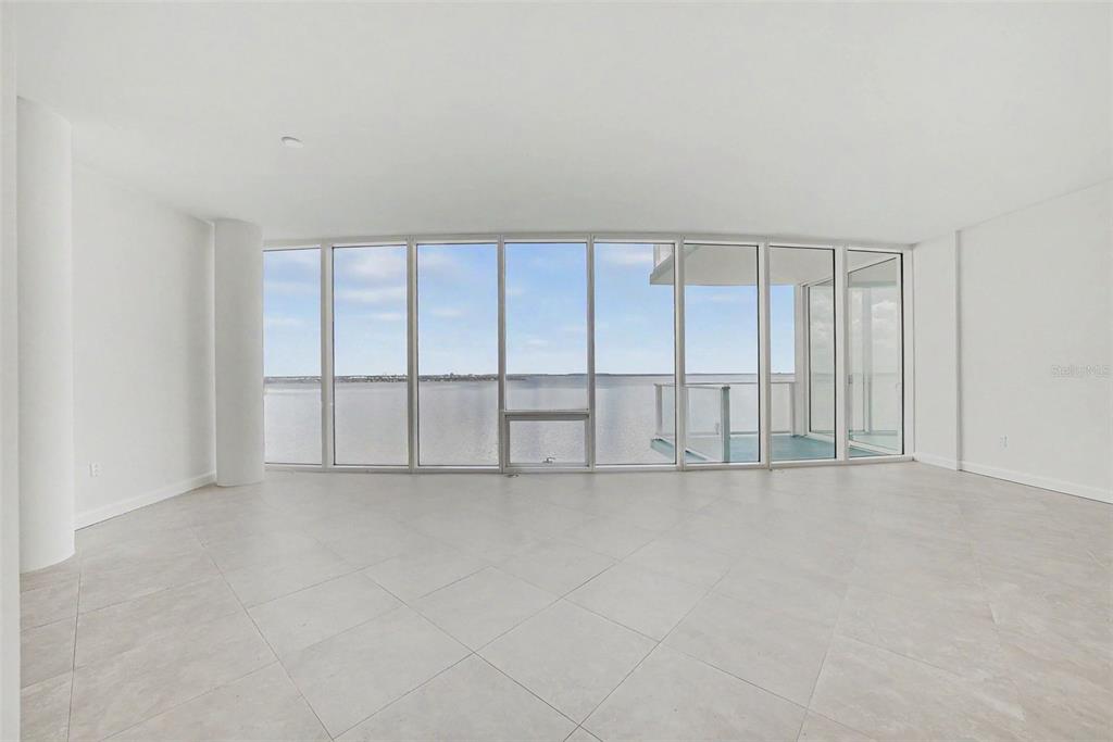 An empty room with large floor-to-ceiling windows overlooking a body of water — 2900 W BAY TO BAY BOULEVARD UNIT 1502, TAMPA, FL