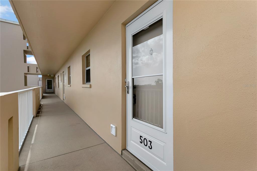 An exterior hallway with a white door labeled 503 and a white metal railing — 3640 IRONWOOD CIRCLE UNIT 503N, BRADENTON, FL