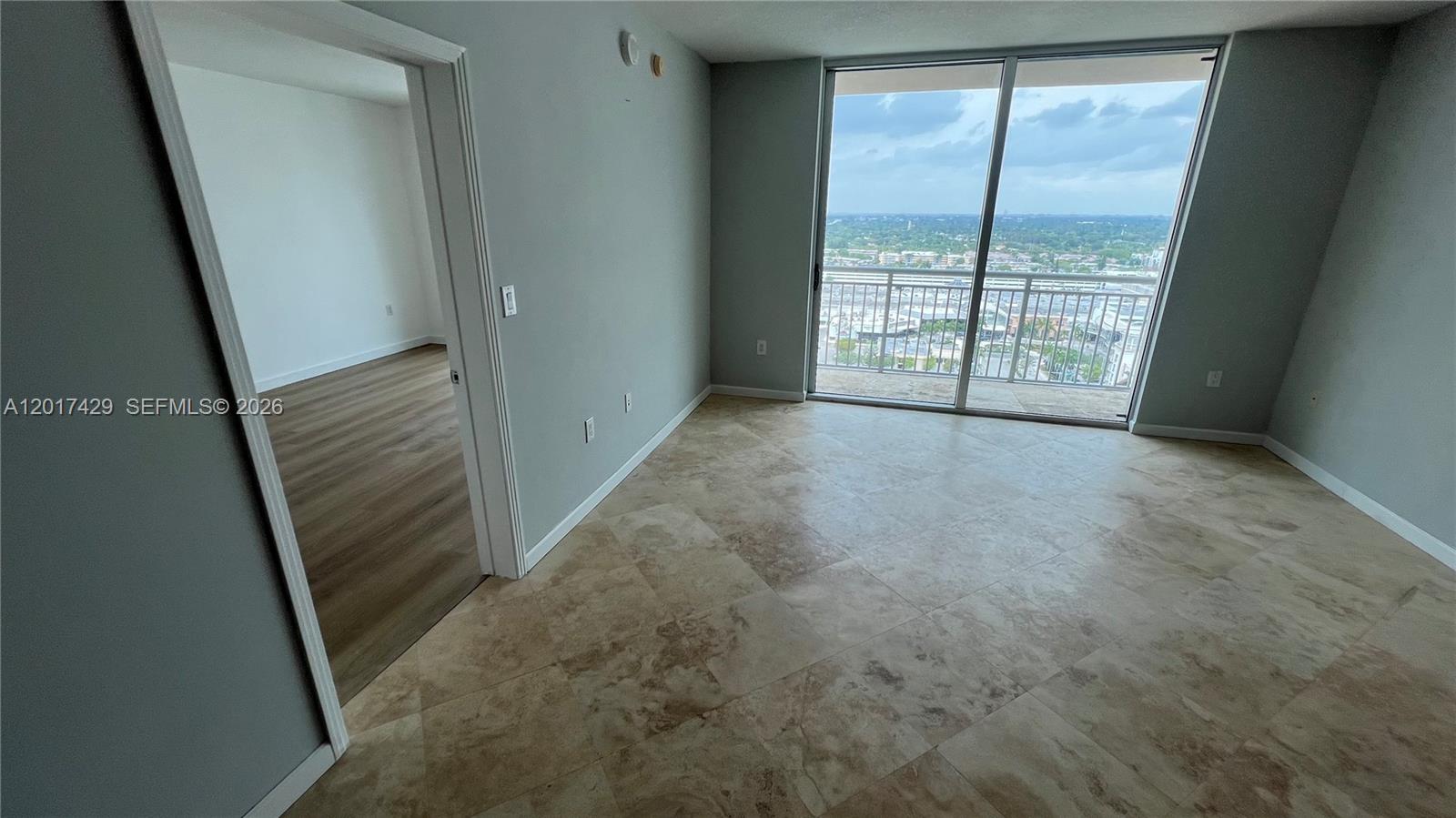 A room with tile flooring and a sliding glass door leading to a balcony — 9055 SW 73rd Ct # 2007, Miami FL 33156, MIAMI, FL