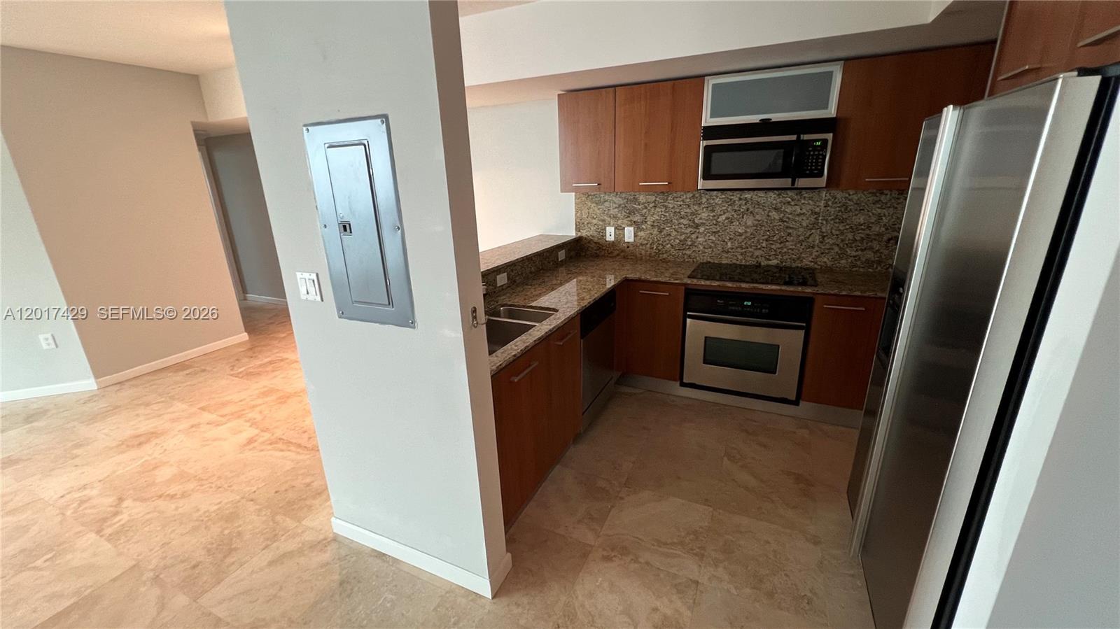 A kitchen features wood cabinets, granite countertops, stainless steel appliances, and tile flooring — 9055 SW 73rd Ct # 2007, Miami FL 33156, MIAMI, FL