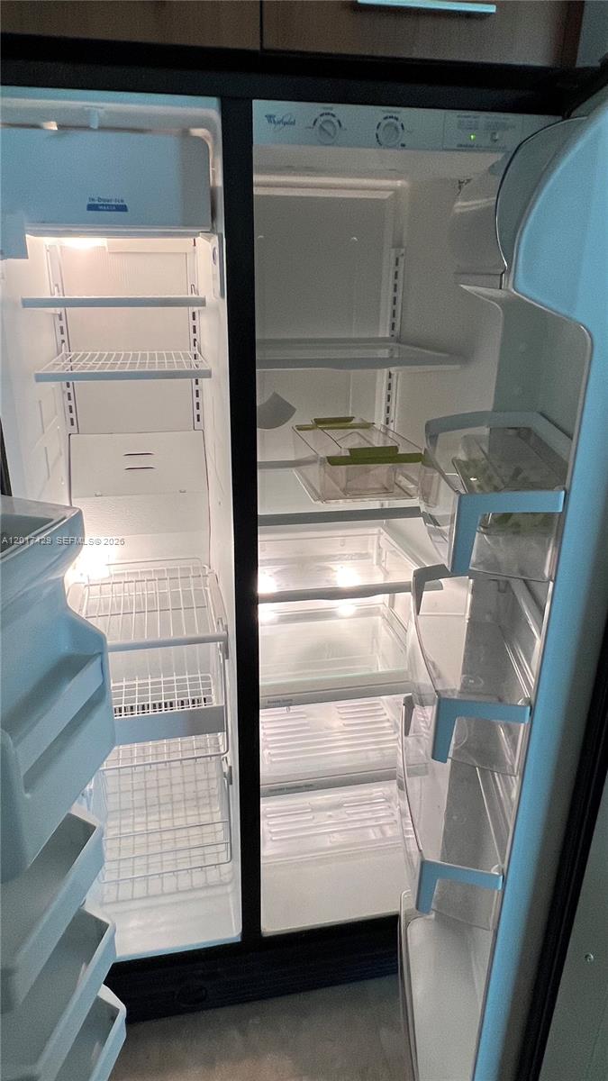 An open side-by-side refrigerator with wire shelves, glass shelves, and plastic door bins — 9055 SW 73rd Ct # 2007, Miami FL 33156, MIAMI, FL