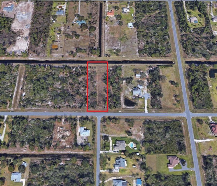 An aerial view shows a rectangular vacant lot outlined in red within a residential area — REYNOLDS PARKWAY, ORLANDO, FL