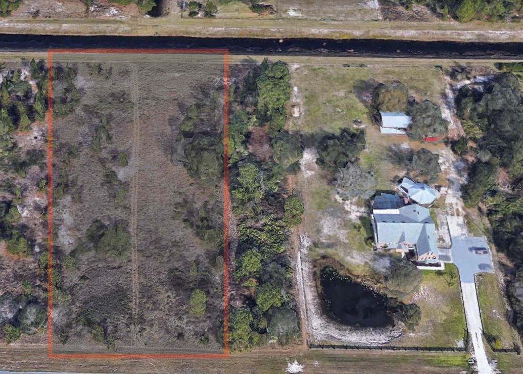 An aerial view shows a rectangular, undeveloped plot of land outlined in red — REYNOLDS PARKWAY, ORLANDO, FL