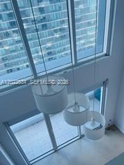Three white pendant lights hang in front of floor-to-ceiling windows overlooking a city skyline — 60 SW 13th St # 3622, Miami FL 33130, MIAMI, FL
