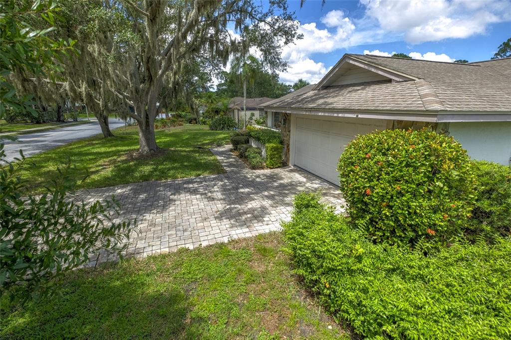 A paved driveway leads to the garage of a single-story house with a shingled roof — 5115 EVERWOOD RUN, SARASOTA, FL