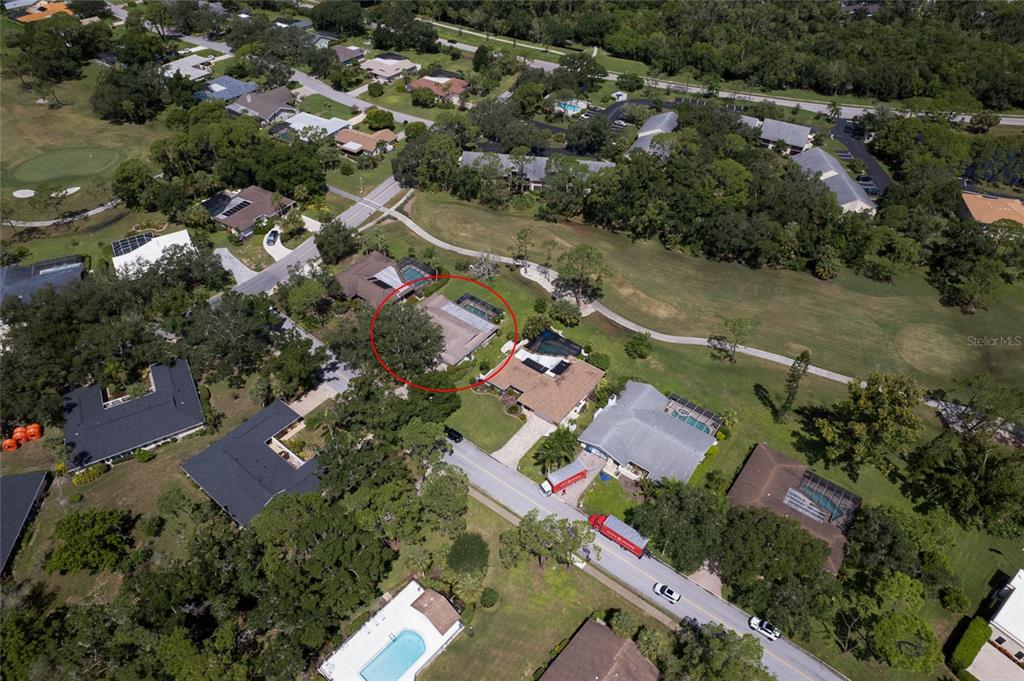 An aerial view shows a residential neighborhood with a red circle highlighting a specific house — 5115 EVERWOOD RUN, SARASOTA, FL