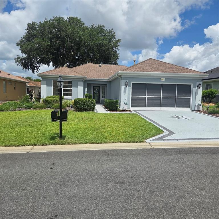 A single-story house with a light blue exterior, a brown roof, and a paved driveway — 9524 SE 124TH LOOP, SUMMERFIELD, FL