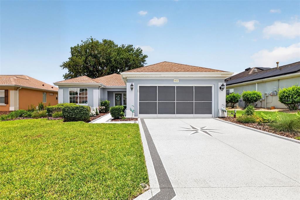 A single-story house with a light gray exterior, a two-car garage, and a paved driveway — 9524 SE 124TH LOOP, SUMMERFIELD, FL