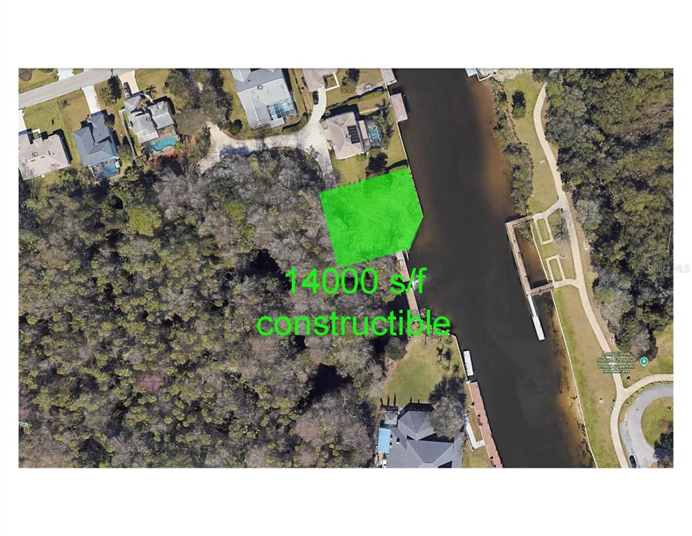 This is an aerial map showing a highlighted waterfront lot next to a nature preserve — 34 COLECHESTER LANE UNIT C, PALM COAST, FL