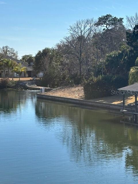 A view of a calm lake with a concrete seawall and a wooden boat dock — 34 COLECHESTER LANE UNIT C, PALM COAST, FL