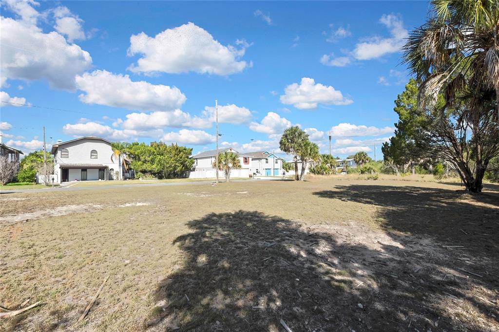 A vacant, grassy lot with scattered trees under a blue sky with white clouds — 3202 ROSE ARBOR DRIVE, HERNANDO BEACH, FL