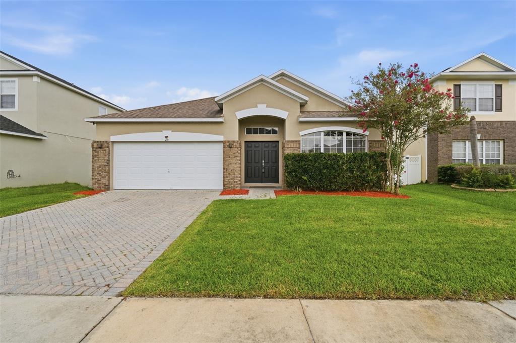 A single-story suburban house with a paved driveway, two-car garage, and a manicured front lawn — 231 DOE RUN DRIVE, WINTER GARDEN, FL