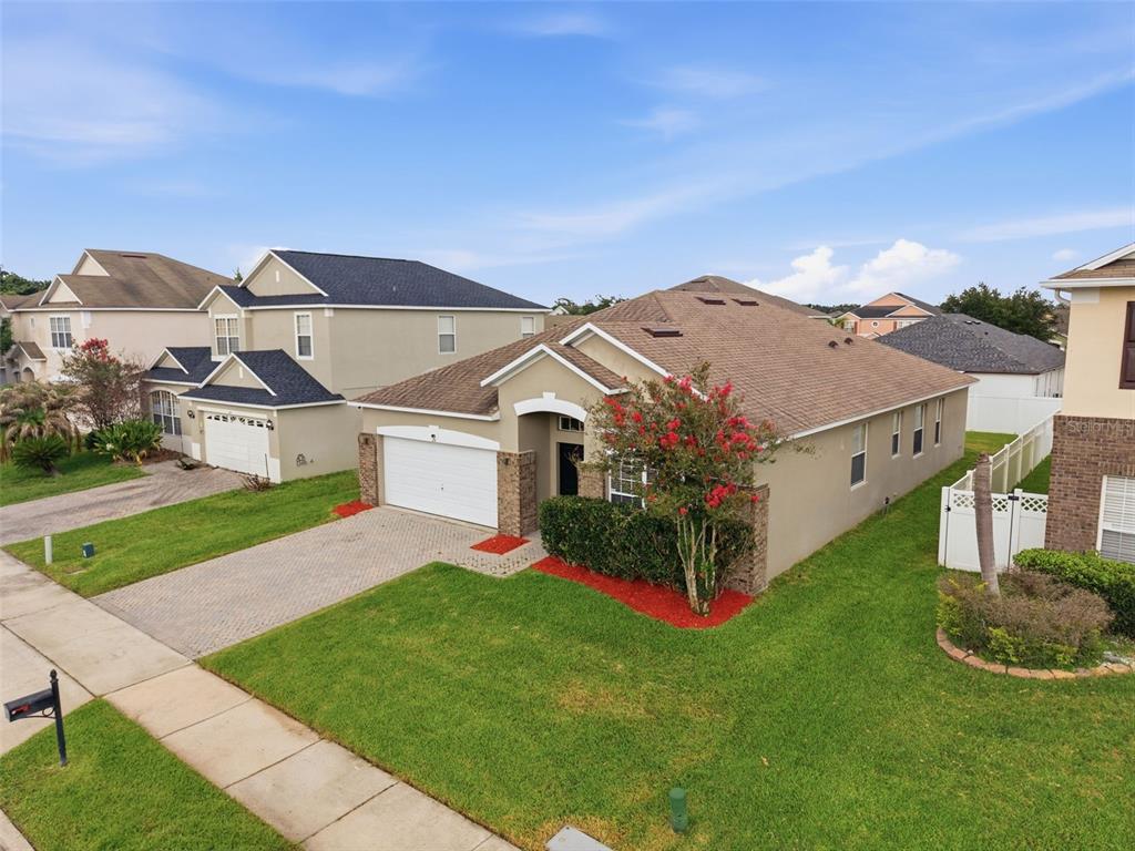 An elevated view of a single-story suburban house with a paved driveway and green lawn — 231 DOE RUN DRIVE, WINTER GARDEN, FL