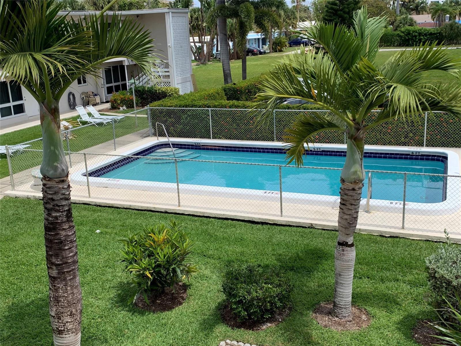 A rectangular swimming pool is enclosed by a chain-link fence in a grassy backyard — 3205 SE 7th Street # 201, Pompano Beach FL 33062, POMPANO BEACH, FL