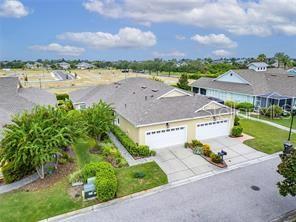 An aerial view shows a tan duplex with two garages and a shared driveway — 210 LATITUDE PLACE, APOLLO BEACH, FL