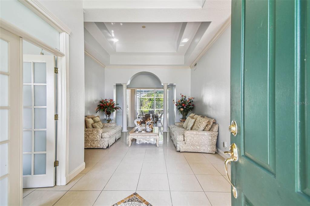 A view from an open doorway into a formal living room with tile flooring — 10526 GREENCREST DRIVE, TAMPA, FL