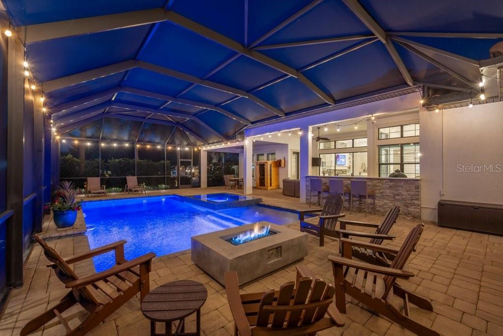 A screened-in patio features a swimming pool, a hot tub, and a stone fire pit — 5201 ALAFIA FALLS DRIVE, LITHIA, FL
