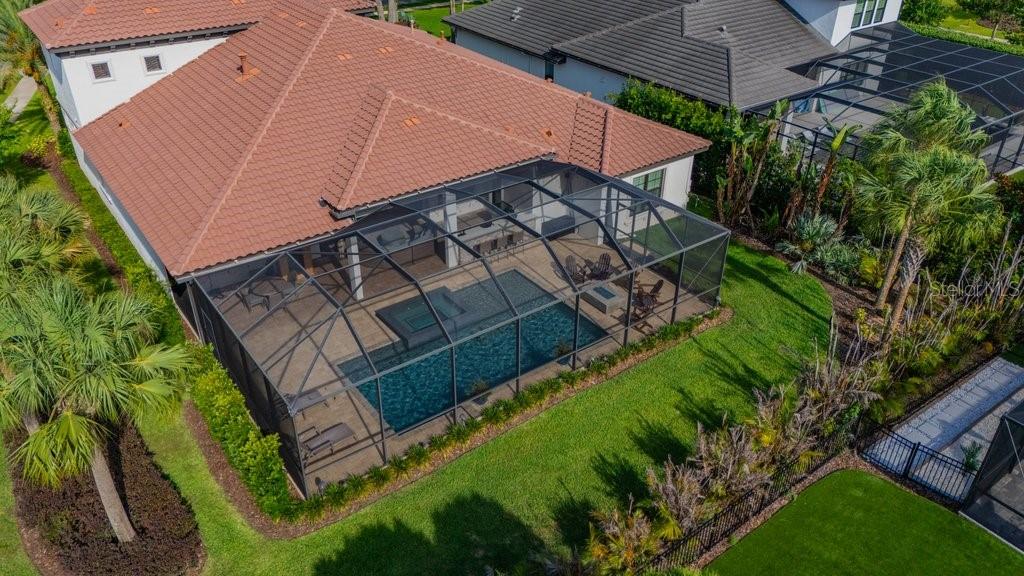 An aerial view of a house with a screened-in pool, patio, and fenced backyard — 5201 ALAFIA FALLS DRIVE, LITHIA, FL