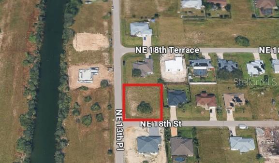 This aerial map shows a vacant residential lot outlined in red — 1321 NE 18TH STREET, CAPE CORAL, FL