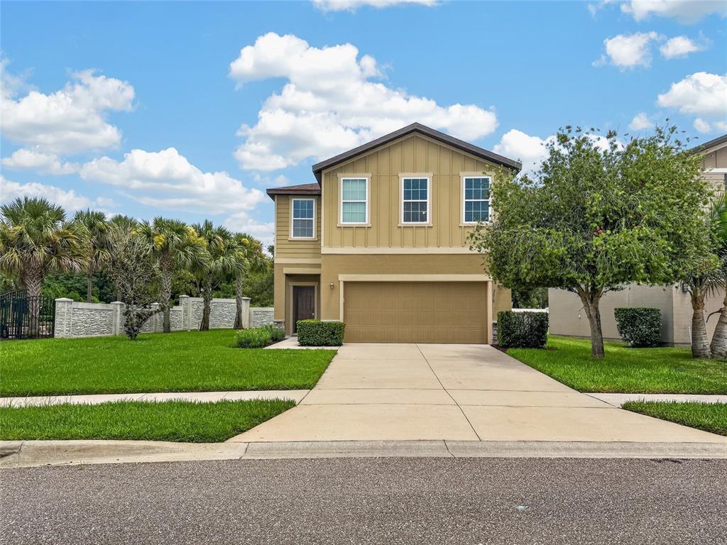 A two-story house with a tan exterior, a two-car garage, and a front lawn — 2610 FLICKER COVE, SANFORD, FL