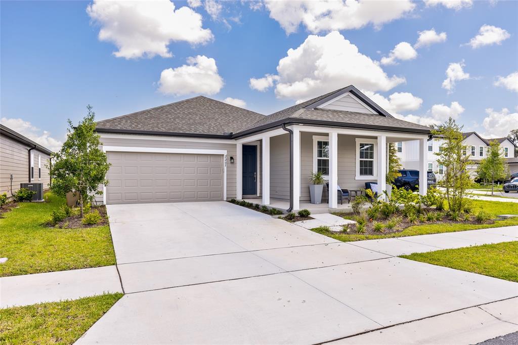 A single-story house with gray siding, a two-car garage, and a covered front porch — 2205 BROADBROOK DRIVE, ST CLOUD, FL