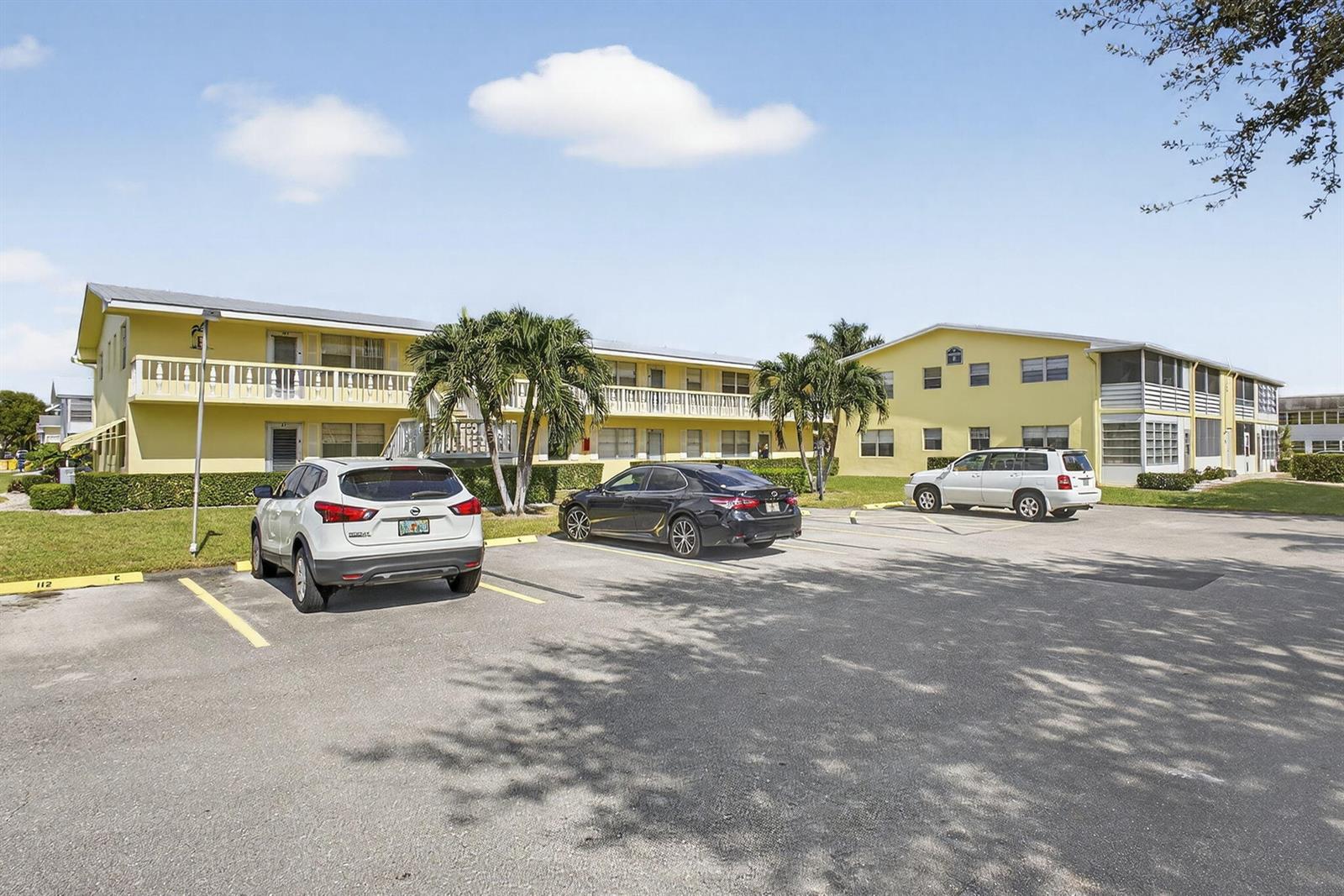 A yellow two-story apartment building with a parking lot in front — 100 Sheffield E, West Palm Beach FL 33417, WEST PALM BEACH, FL
