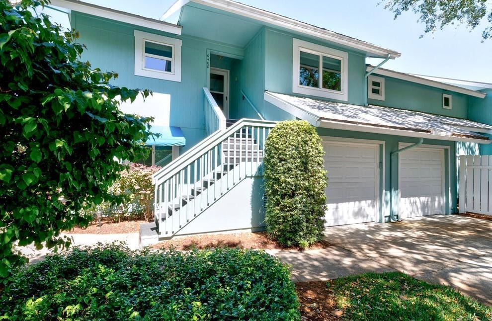 A two-story light blue house features a front staircase, two garage doors, and landscaping — 6408 S River Run Drive, Sebastian FL 32958, SEBASTIAN, FL