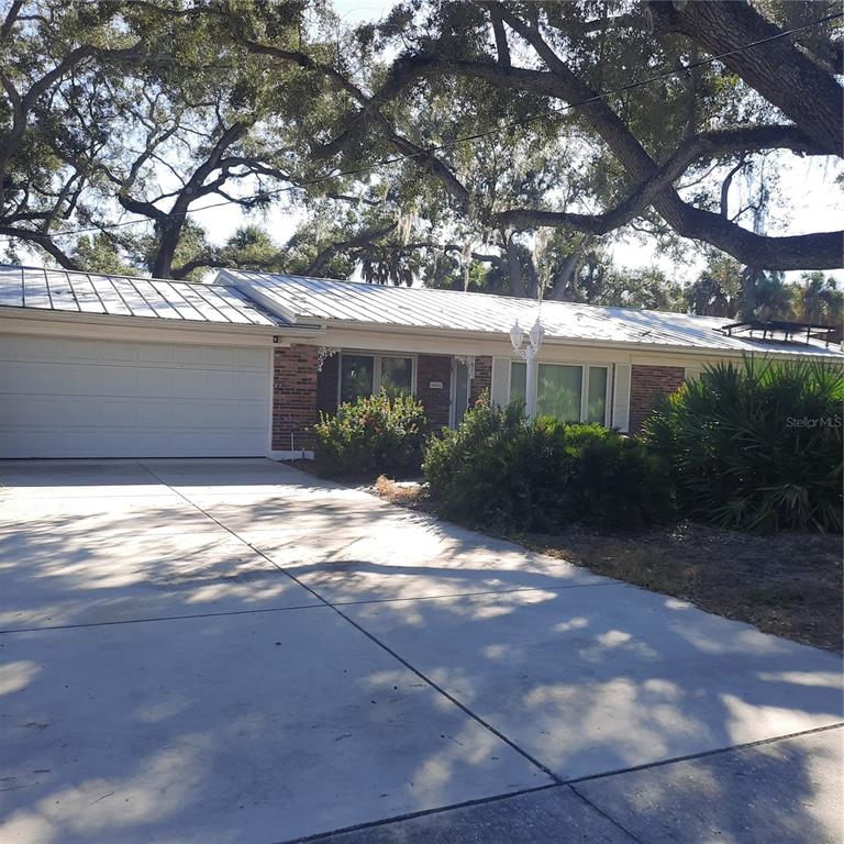 A single-story brick house with a metal roof and an attached two-car garage — 4806 W SAN JOSE STREET, TAMPA, FL