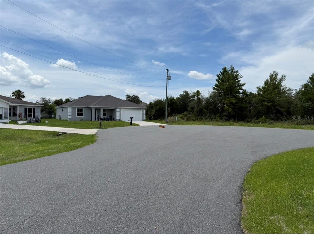 A paved cul-de-sac street leads to a single-story house with a two-car garage — 1205 WAVERLY PLACE, KISSIMMEE, FL