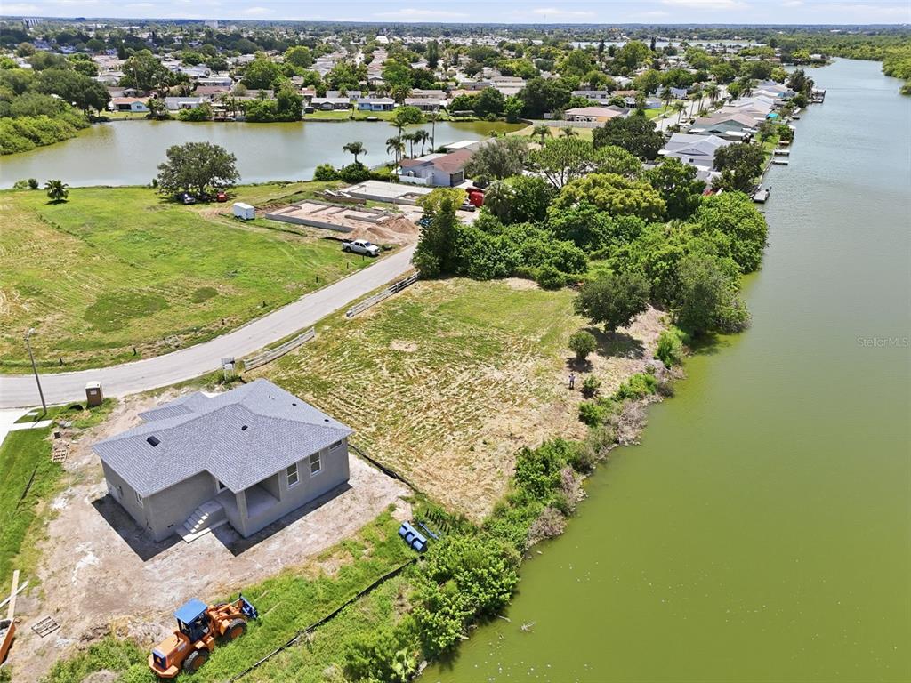 An aerial view shows a new house under construction next to a large body of water — 1503 JACKSON DRIVE, HOLIDAY, FL