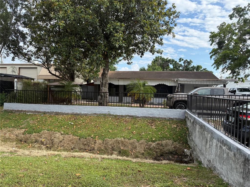 A single-story house with a fenced front yard and a concrete retaining wall — 4106 W SOUTH AVENUE, TAMPA, FL