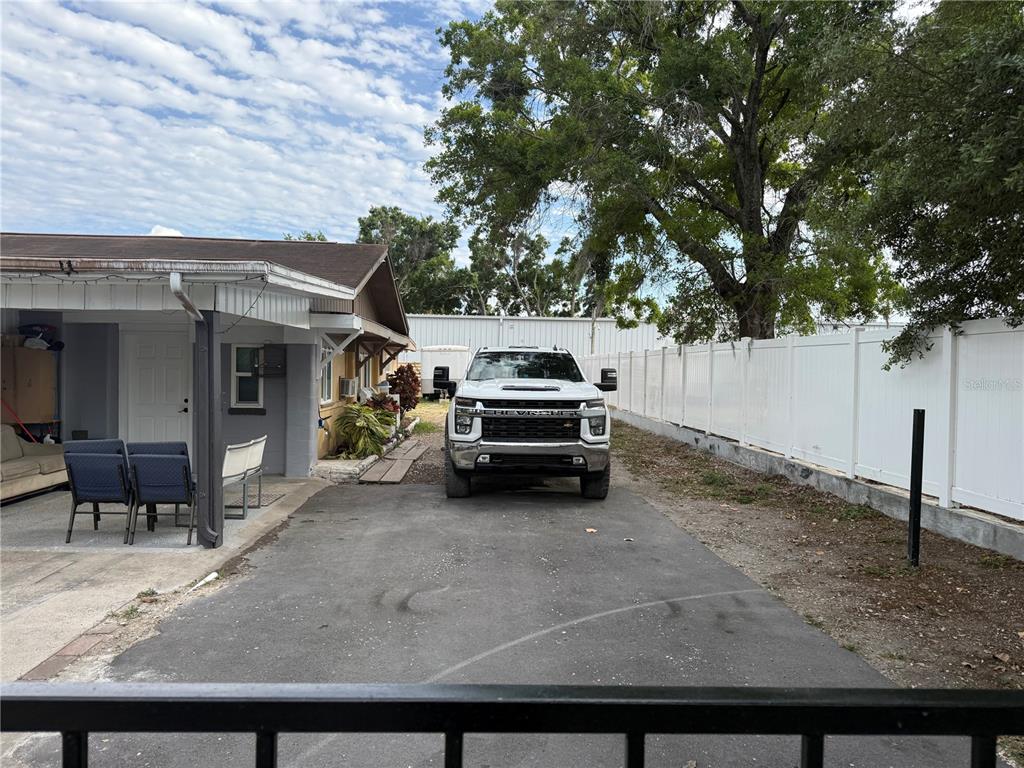 A white pickup truck is parked on a paved driveway next to a house exterior — 4106 W SOUTH AVENUE, TAMPA, FL