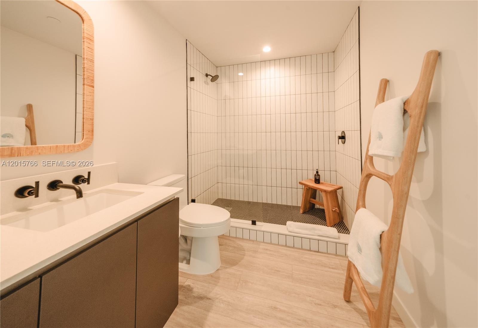 A modern bathroom features a walk-in shower with white vertical tiles and a wooden ladder — 275 SW 6th St # 5303, Miami FL 33130, MIAMI, FL