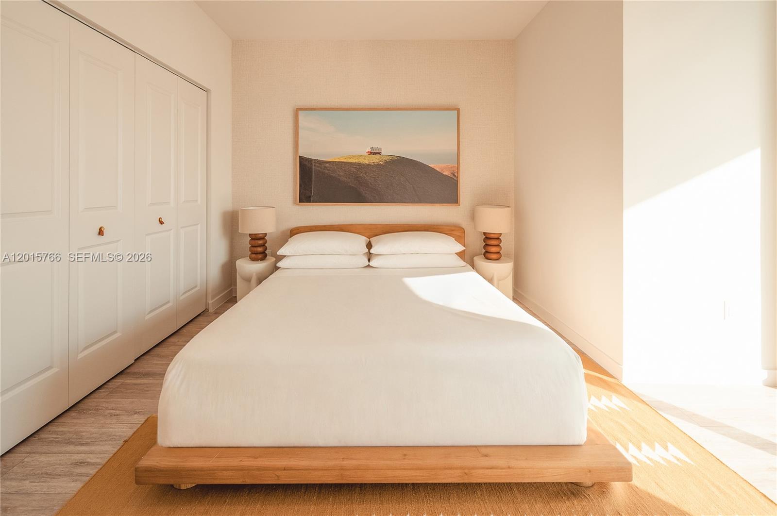 A bedroom features a platform bed, two bedside lamps, and a framed landscape wall art — 275 SW 6th St # 5303, Miami FL 33130, MIAMI, FL