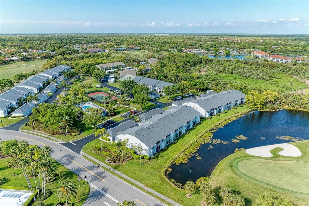 Aerial view of multi-story residential buildings, a swimming pool, and a pond on a golf course — 4639 CHAPEL HILL DRIVE UNIT 2925, SARASOTA, FL