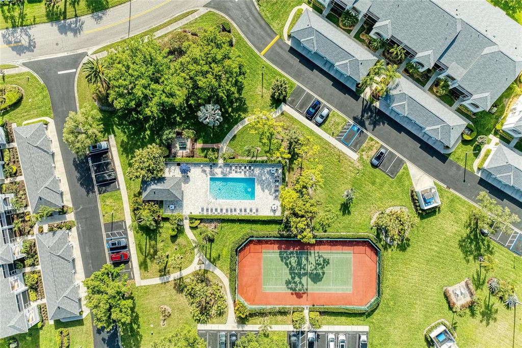 An aerial view shows a swimming pool, tennis court, and surrounding apartment buildings with parking — 4639 CHAPEL HILL DRIVE UNIT 2925, SARASOTA, FL