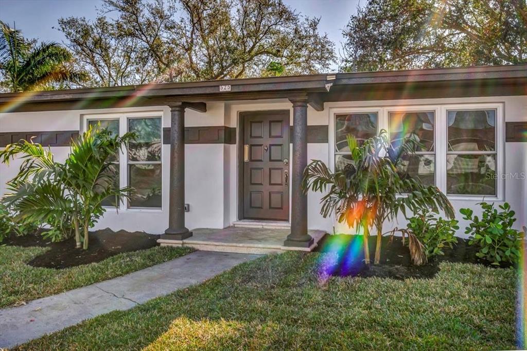 The exterior of a single-story house features a dark front door and two decorative columns — 525 LAMARA WAY NE, ST PETERSBURG, FL