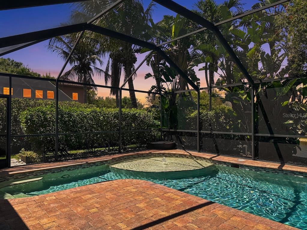 A screened-in pool area features a circular spa with a fountain and brick paver decking — 6772 SOUTHERN OAK COURT, NAPLES, FL