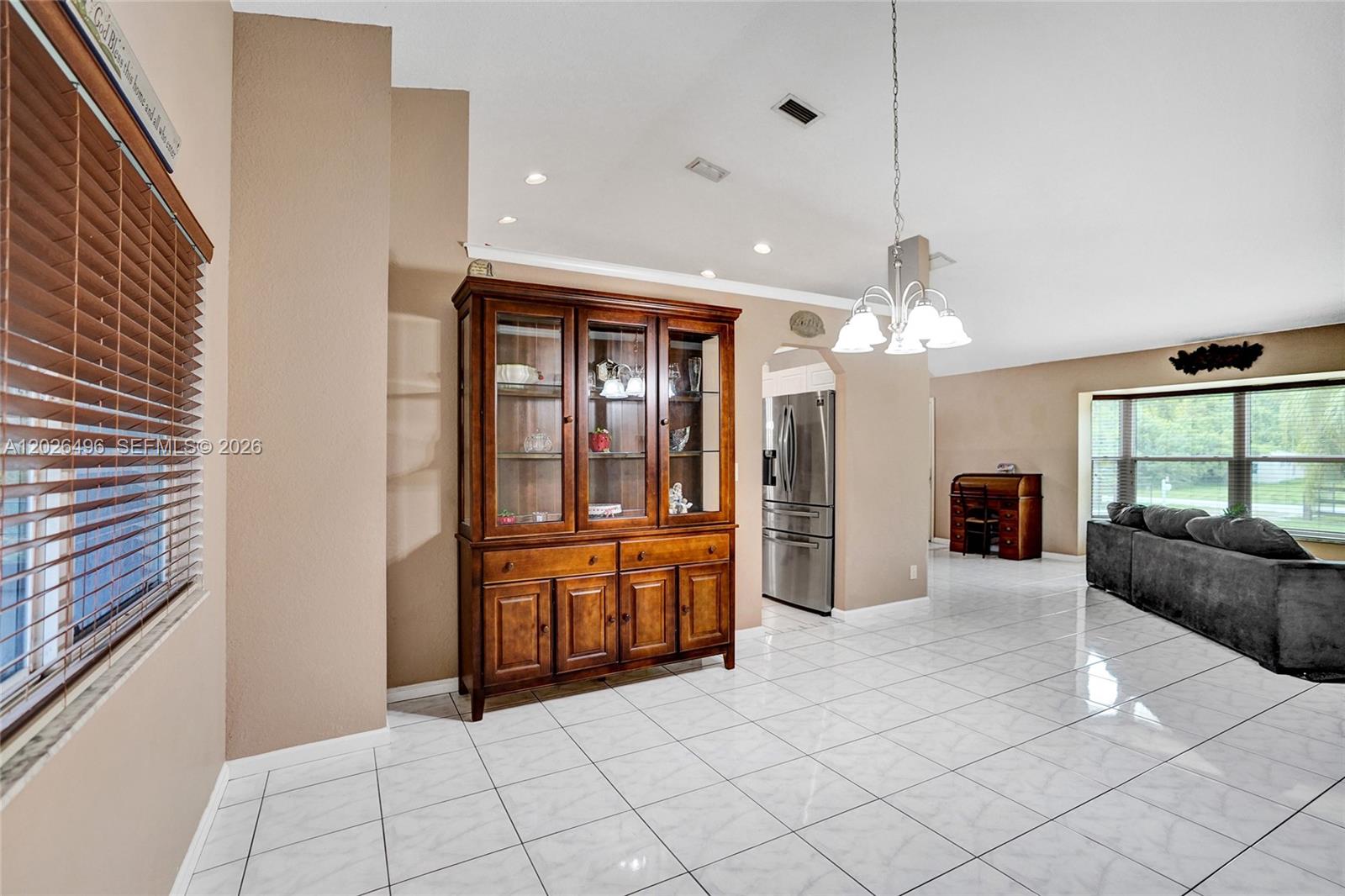A dining area features tile flooring, a wooden hutch, and a chandelier — 14808 N 69th St N, Loxahatchee FL 33470, LOXAHATCHEE, FL