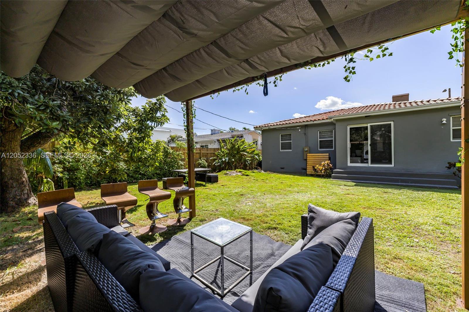 A backyard features a patio with outdoor furniture, a pergola, and a gray house — 285 NW 45th St # 0, Miami FL 33127, MIAMI, FL